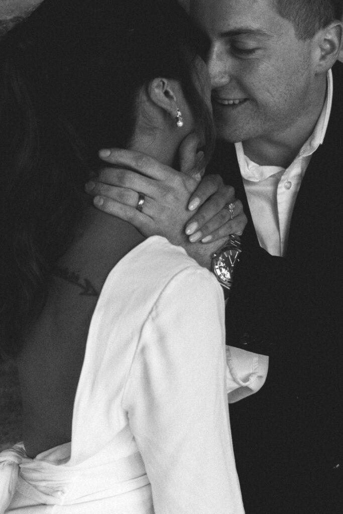 close up of husband smiling at his wife before kissing her